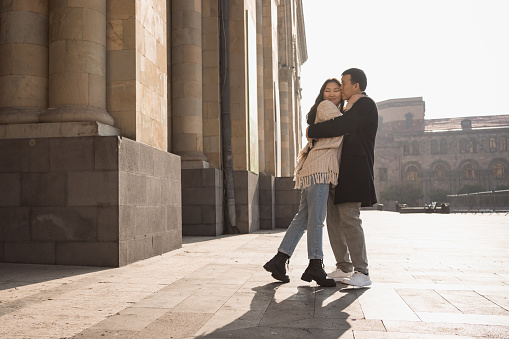 Happy young adult asian couple in love meeting for date in Republic Square of Yerevan