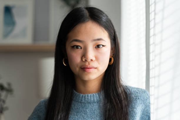 istock Serene asian woman by window light 2147696794