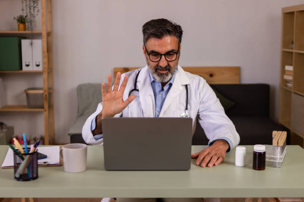 istock Friendly doctor greeting via video call 2147696932