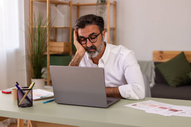 istock Stressed businessman working on laptop at home office 2147697015