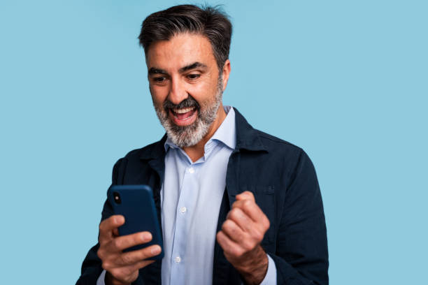 istock Excited businessman celebrating success with smartphone 2147698819