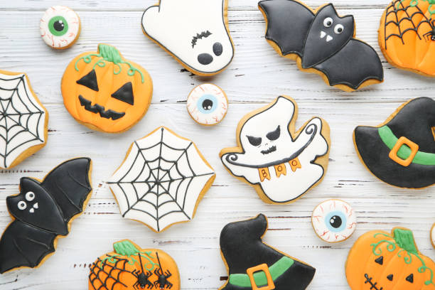istock Halloween gingerbread cookies on white wooden table 2147699283