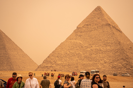 Giza, Cairo, Egypt - April 9, 2023 Tourists in front of the Giza Necropolis pyramids complex. Egypt, Africa