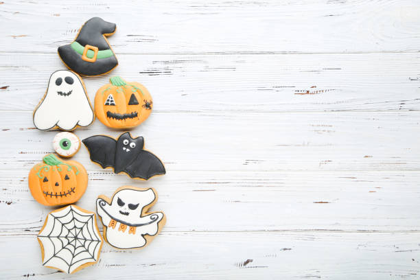 istock Halloween gingerbread cookies on white wooden table 2147699528