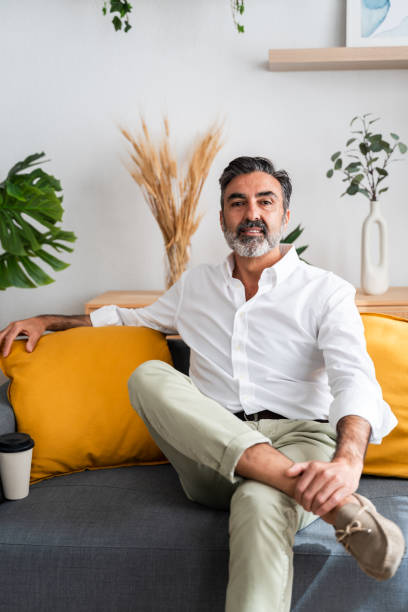 istock Confident mature man relaxing on sofa at home 2147699587