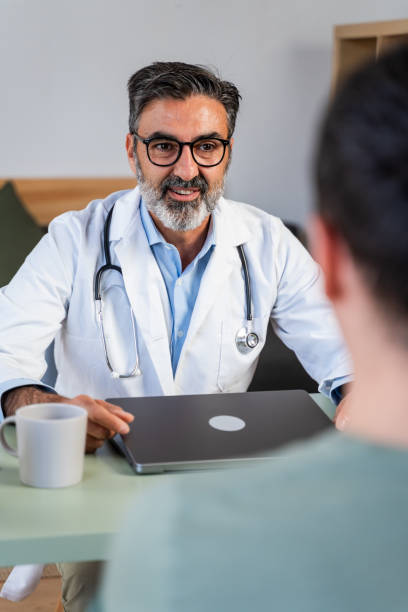 istock Confident doctor consulting with patient in office 2147701172