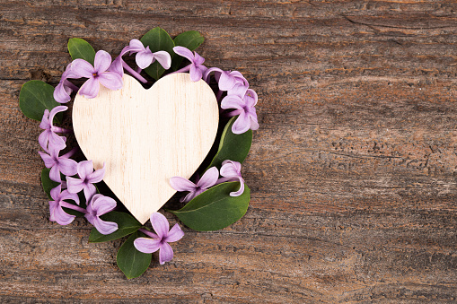 Decorative  heart and  flowers on old wooden background