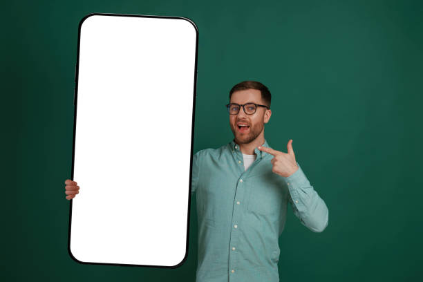 istock With massive smartphone with empty white color. Man is standing against background in the studio 2147701463