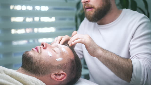 Relaxed Male Getting Forehead Massage By Beautician