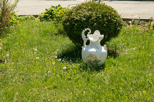 Clay pot on green summer lawn in the garden