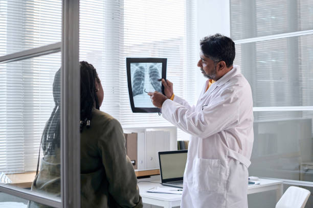 Senior Doctor Pointing at Chest X Ray