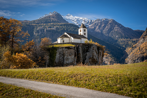 Church on top of hill below glaciated mountains