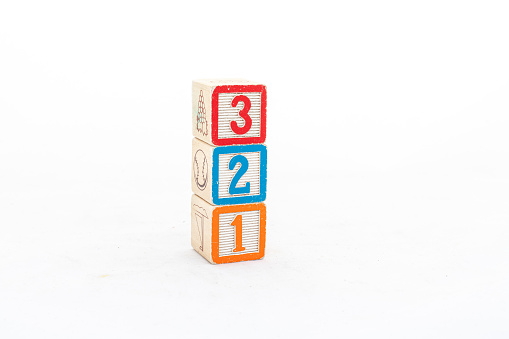 Stacked wooden cubes with numbers three, two and one isolated on white background