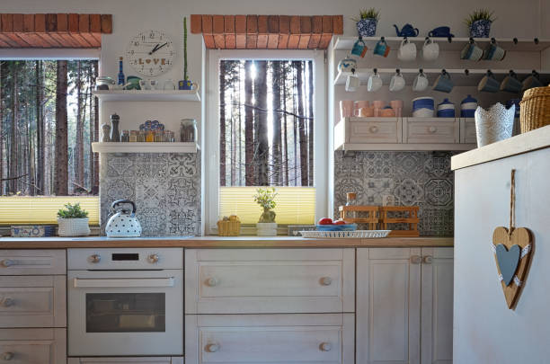 istock Cosy kitchen with view through window on forest and wooden countertop with oven. Home interior. 2147707620