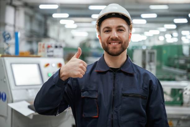 istock Showing thumb up. Factory worker is indoors with hard hat 2147708582