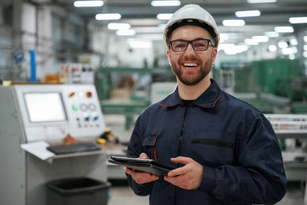 istock Holding tablet. Factory worker is indoors with hard hat 2147708731