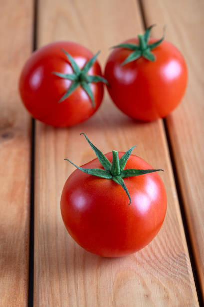 A group of red bunch tomatoes on a wooden table
