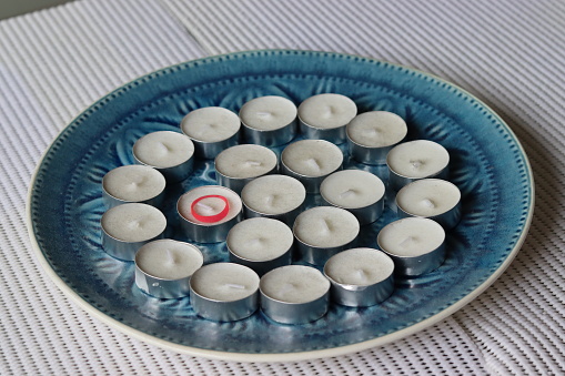 Small white candles in a blue tray.
