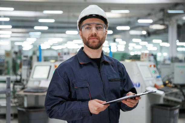 istock Smart employee. Factory worker is indoors with hard hat 2147709190