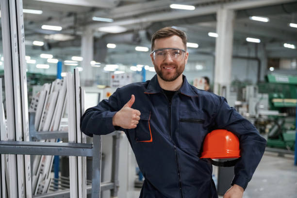istock Break time, standing. Factory worker is indoors with hard hat 2147709285