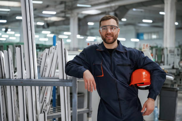 istock Break time, standing. Factory worker is indoors with hard hat 2147709296
