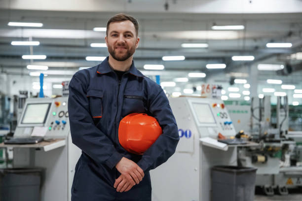 istock Break time, standing. Factory worker is indoors with hard hat 2147709313