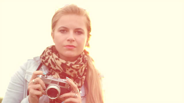 Young woman taking photo pictures with retro camera