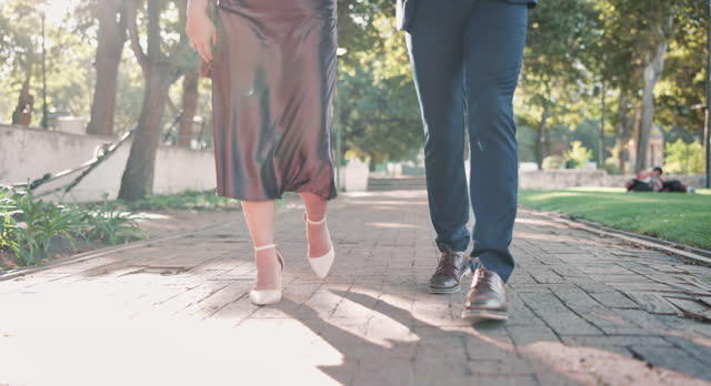 Couple, feet and walking to date, road and nature in park, elegant and closeup up on legs and shoes. Outdoor, person and partner with glamour for romance, love and peace to relax in relationship