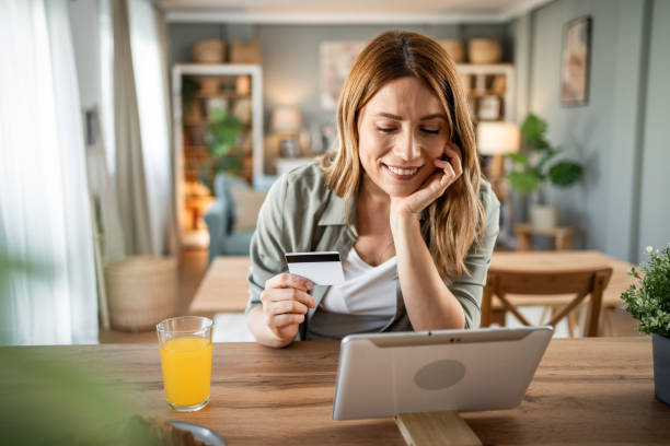 istock A woman is sitting in her room checking her monthly budget via internet banking, using a digital tablet and credit card 2147709859
