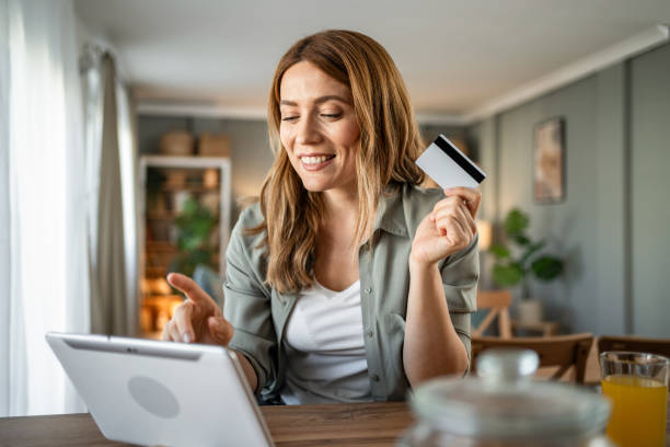 istock A woman is sitting in her room checking her monthly budget via internet banking, using a digital tablet and credit card 2147710075