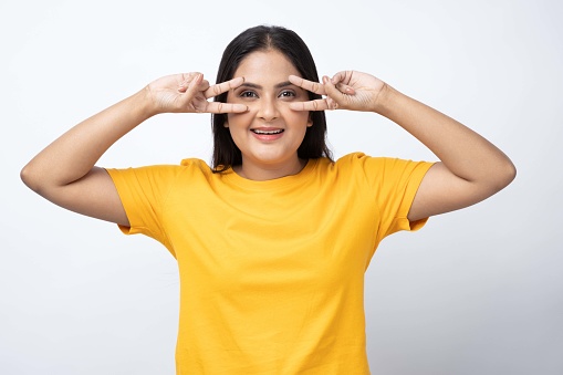 Portrait of young girl wearing yellow t-shirt on white background
