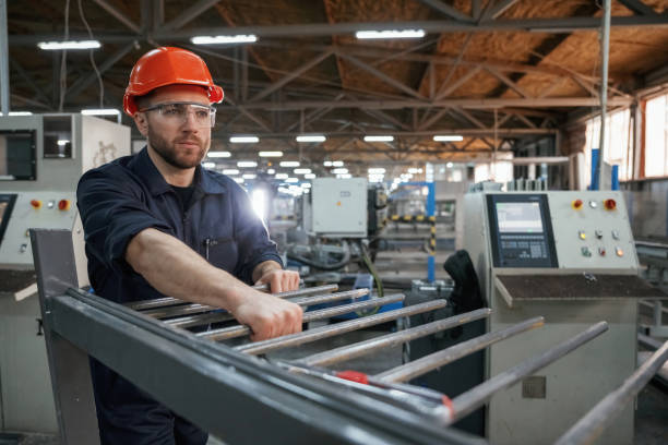 istock Industrial line, working. Factory worker is indoors with hard hat 2147711289