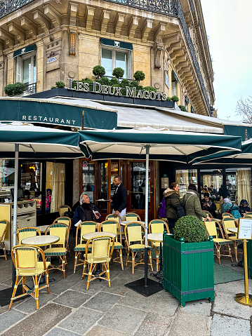 Paris, France - 21.02.2024. Les Deux Magots iconic brasserie serves traditional French fare in an airy, charming space in Paris. Saint Germain des Pres boulevard and place. Winter, early spring or autumn in Paris