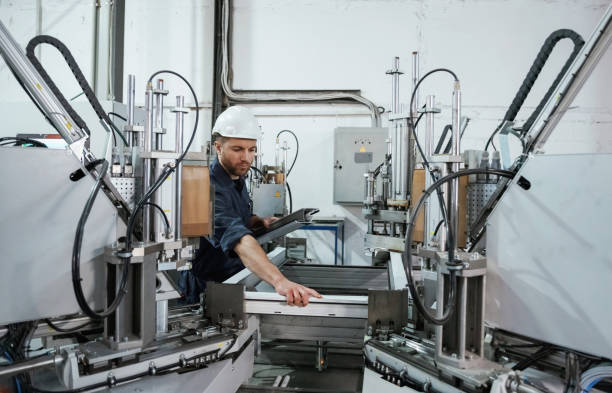 istock Industrial line, working. Factory worker is indoors with hard hat 2147711533