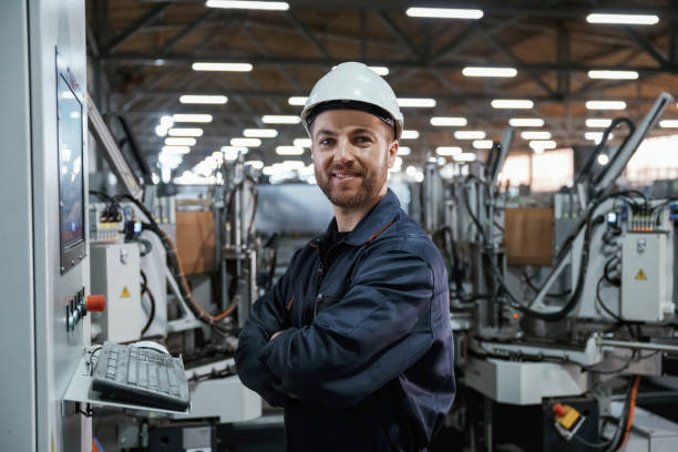 istock Using equipment, operator. Factory worker is indoors with hard hat 2147711540