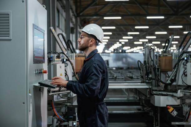 istock Using equipment, operator. Factory worker is indoors with hard hat 2147711560