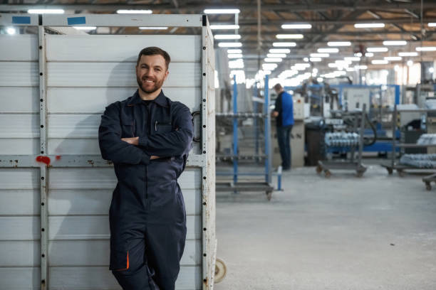 istock Just standing and smiling. Factory worker is indoors 2147711701