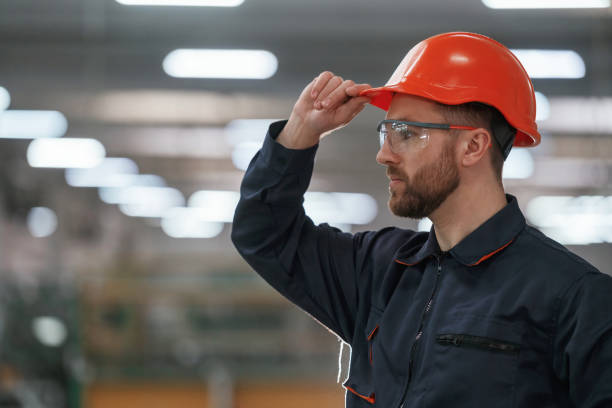 istock Blurred background. Factory worker is indoors with hard hat 2147711736