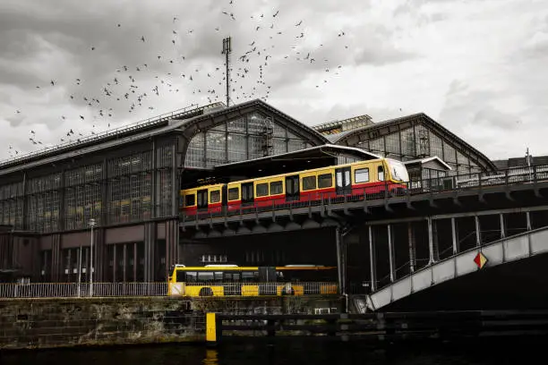 Friedrichstrasse railway station in Berlin. Train on the platform, a flock of birds above the terminal, view from the river