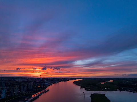 Kampen and river IJssel during a spring colorful sunset at the end of a springtime day with colorful clouds in the sky.