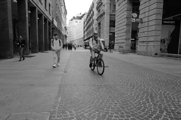 Milan, Italy - April 09, 2024: some people on foot and others on bicycles are crossing Piazza del Duomo in Milan