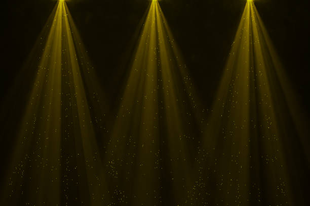 istock Golden spotlight rays with sparkles overlay on black background 2147714505
