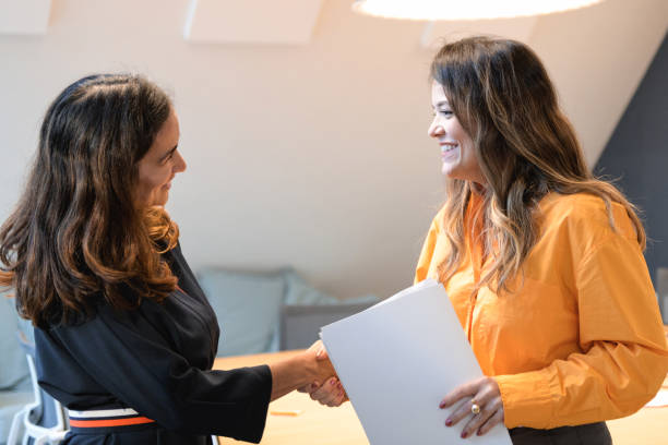 istock two woman shaking hands in office 2147714605