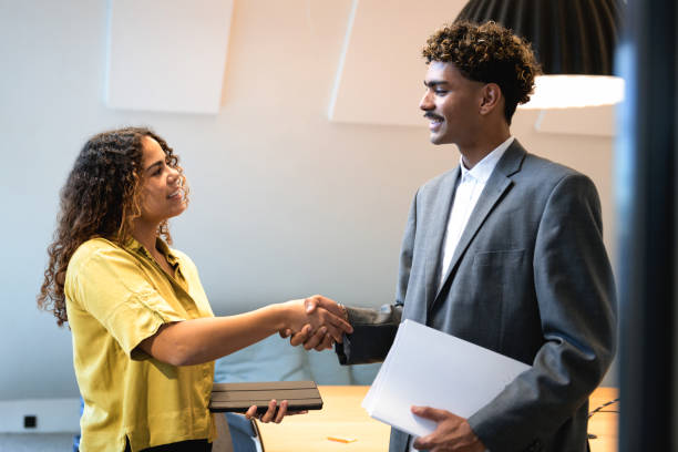 istock young woman shaking hands with young man in office 2147714977