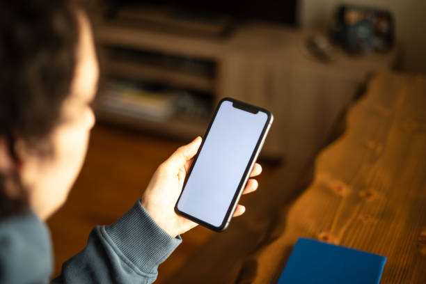 istock A woman is looking her mobile phones white screen at home. 2147715518