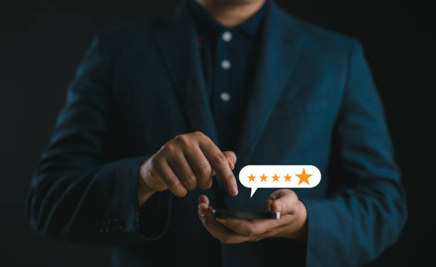 istock close up Man hand using smartphone with popup five star icon for feedback review satisfaction service, Customer service experience and business satisfaction survey. 2147715895