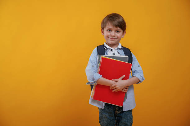istock Little boy is in the studio against yellow background 2147717740