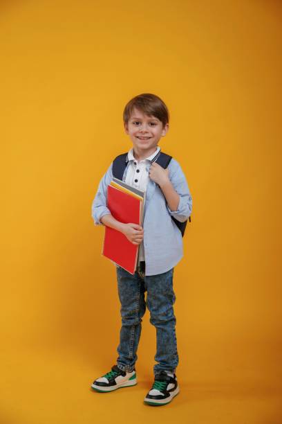 istock Little boy is in the studio against yellow background 2147717784