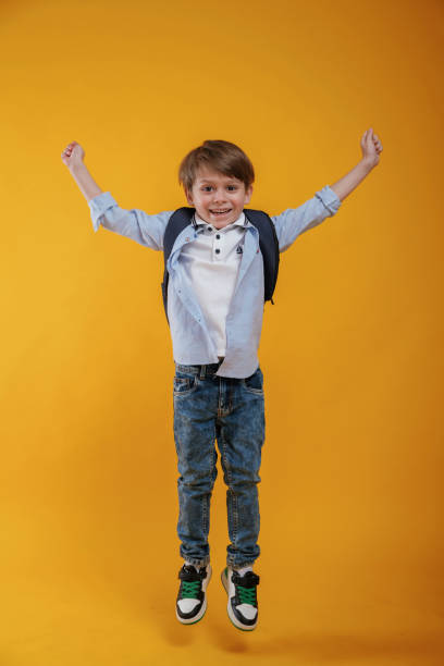 istock Front view. Little boy is in the studio against yellow background 2147717786