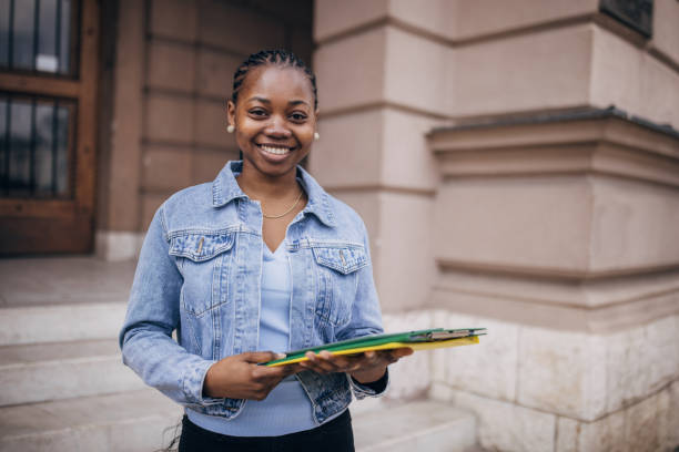istock Smiling college student holding books on campus 2147717880